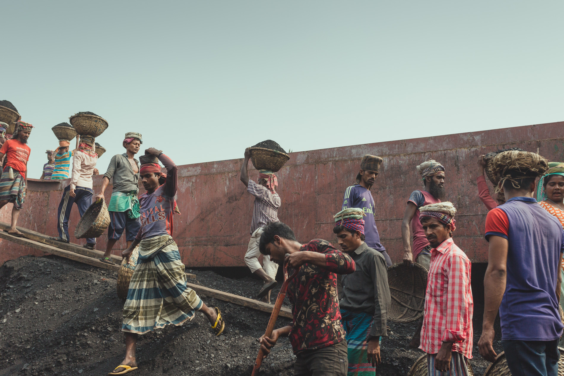 The coal workers at Dhaka, Bangladesh are consistently walking up and down with loads of coal on their heads.