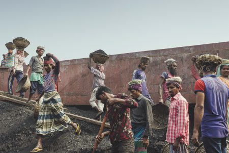 Coal workers walk up and down in hot conditions and wait a turn to fill up their baskets The coal workers at Dhaka, Bangladesh are consistently walking up and down with loads of coal on their heads.