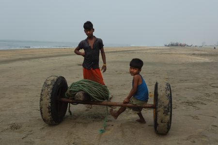 Two boys at leisure on the sands of Bengal Boys at Bay of Bengal Cox’s Bazar Bangladesh wait with boat transport equipment
