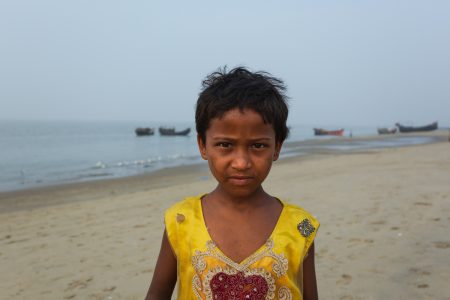 Portrait of a girl in a yellow top on the beaches of Bengal Coy young girl at Bay of Bengal Cox’s Bazar Bangladesh poses for photograph