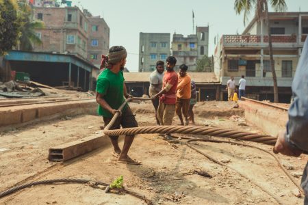 Team of men working to move cables without any protective gear. Team of men working to move cables at Dhaka, Bangladesh Shipyard.