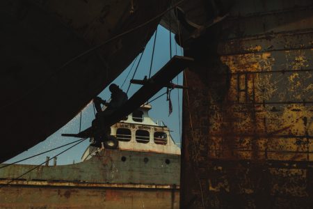 Due to the large size of the vessels, workers use wooden platforms to access all areas. These platforms are supported by ropes that, in most cases, do not offer adequate safety against accidents. Worker on light platform to access the side of the ship at Dhaka, Bangladesh Shipyard.