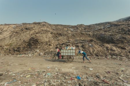 Teamwork is essential at the landfill. Two boys work together to transport a cart full of collected rubbish in Chittagong, Bangladesh.
