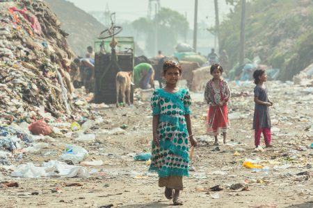 Goodbyes are always sad Girl standing in front of huge rubbish piles in Chittagong, Bangladesh.